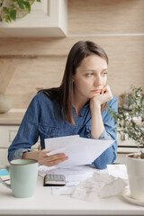woman pays utility bills and writes checks. a European woman at home makes a calculation of...