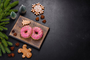A beautiful doughnut with pink glaze and colored sprinkle on a christmas table