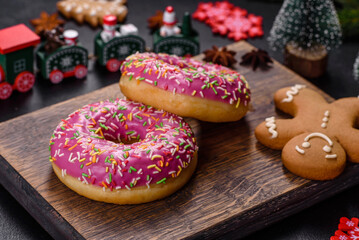 A beautiful doughnut with pink glaze and colored sprinkle on a christmas table