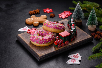 A beautiful doughnut with pink glaze and colored sprinkle on a christmas table