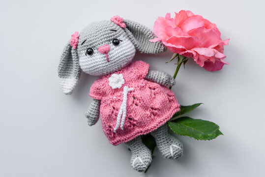 Beautiful knitted rabbit toy with doughnuts with pink glaze and coloured sprinkle