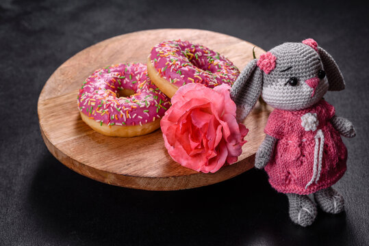 Beautiful knitted rabbit toy with doughnuts with pink glaze and coloured sprinkle