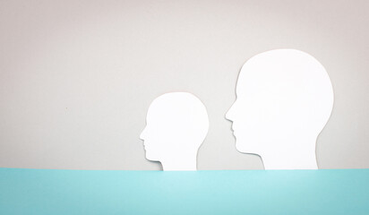 Two silhouette faces looking to the same direction, copy space for text, adult and child, anonymous profil of men, communication concept