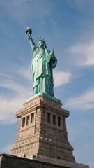Obraz premium Statue of Liberty with Blue Sky few Clouds in Daylight 