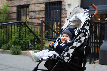 Little beautiful boy in a stroller on the New York street