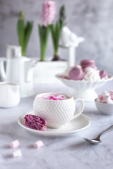 A cup of coffee and macaroons. Photo on a light gray marble background. Selective focus.