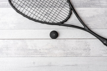 Black squash racket and ball on grey court. Horizontal sport theme poster, greeting cards, headers,...