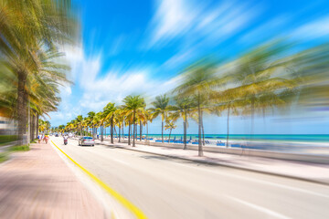 Seafront beach promenade with palm trees on a sunny day in Fort Lauderdale with motion blur effect