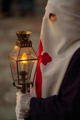 Nazarene with white cap and Templar cross carrying lantern