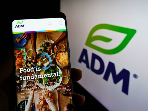 Stuttgart, Germany - 02-06-2022: Person holding cellphone with website of US business Archer-Daniels-Midland Company (ADM) on screen with logo. Focus on center of phone display.