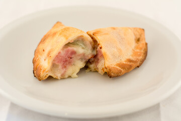 empanada de jamon y queso cortada a la mitad