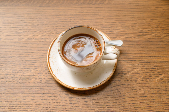Cup of aromatic coffee on wooden table, above view