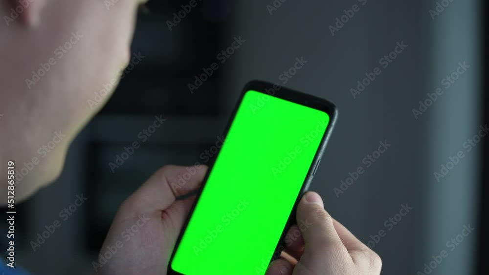 Poster close-up of male hands touching of smartphone. man holds mobile phone in hand with green chromakey s