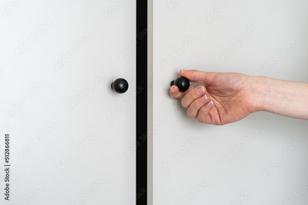 Wall mural Woman opened door at light grey wardrobe