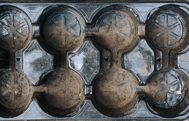 Plastic black round trays, cells for pots close-up. Photography, top view, background, texture.