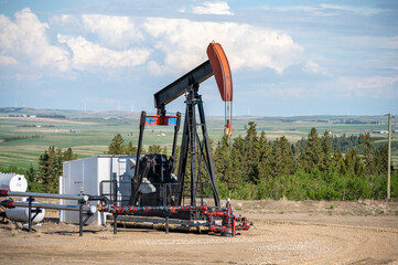 Pumpjacks working in the oil fields of Alberta on a spring day. - obrazy, fototapety, plakaty
