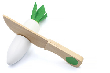 Kids toy wooden vegetables in background close up. Childrens developing wooden game. White carrot