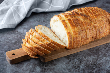 Fresh white loaf of bread on gray cement background. Top view
