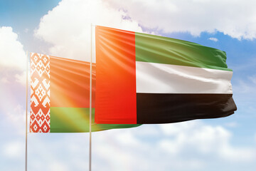 Sunny blue sky and flags of united arab emirates and belarus