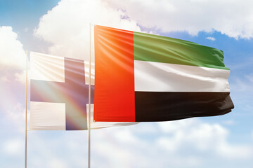 Sunny blue sky and flags of united arab emirates and finland