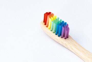 Toothbrush in rainbow colors. Ecological everyday objects. Wooden toothbrush.