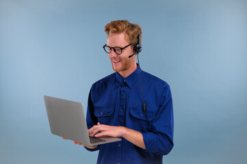 Call center employee talking with earphones with microphone isolated on blue color background