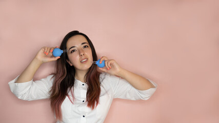 Cosmetology concept. cosmetologist doctor posing with gouache scrapers on a pink background