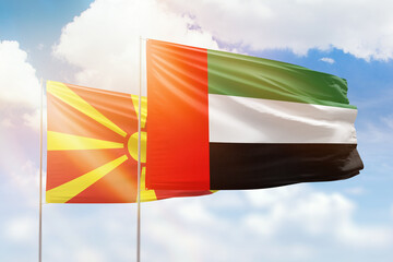 Sunny blue sky and flags of united arab emirates and north macedonia