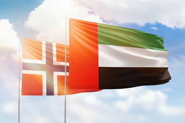 Sunny blue sky and flags of united arab emirates and norway