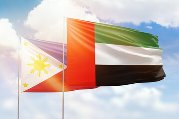 Sunny blue sky and flags of united arab emirates and philippines