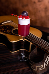 Clover Club Cocktail, a Sour Drink with Gin, Raspberries, and Egg White Foam in a Dark Luxurious Bar with Copy Space