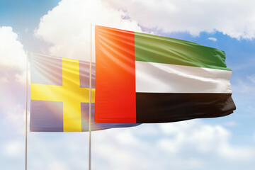 Sunny blue sky and flags of united arab emirates and sweden