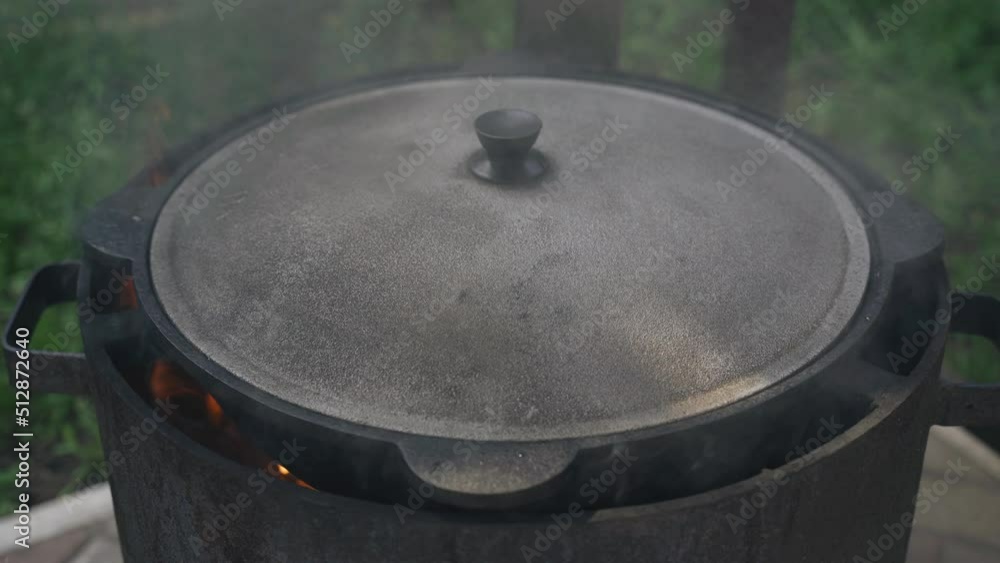 Wall mural Cooking on an open fire. There is a brazier covered with a lid on the fire.