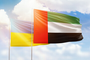 Sunny blue sky and flags of united arab emirates and ukraine