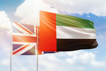 Sunny blue sky and flags of united arab emirates and united kingdom