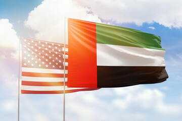 Sunny blue sky and flags of united arab emirates and usa