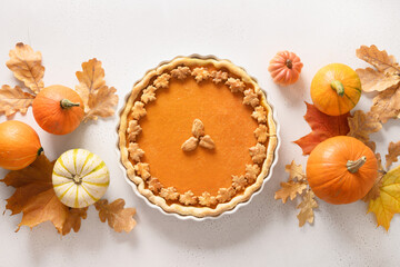 Thanksgiving Day American Pumpkin Pie with squash on white background. View from above. Flat lay....