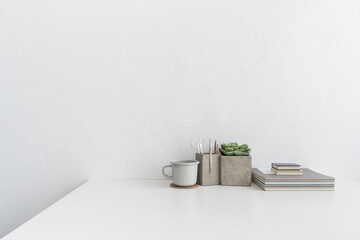 Table at home office against white wall. Stylish minimalist workspace.	