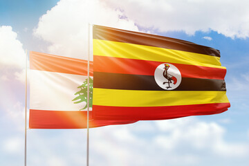 Sunny blue sky and flags of uganda and lebanon