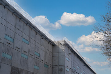 Fototapeta premium high concrete fence, barbed wire fence on top, pre-trial detention cell, building for execution of punishments for criminals, concept prison, security zone, hopelessness of captivity