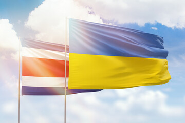 Sunny blue sky and flags of ukraine and costa rica