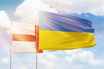 Sunny blue sky and flags of ukraine and england