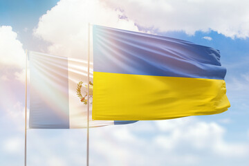 Sunny blue sky and flags of ukraine and guatemala