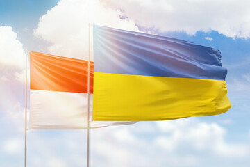 Sunny blue sky and flags of ukraine and indonesia