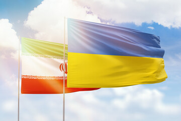 Sunny blue sky and flags of ukraine and iran