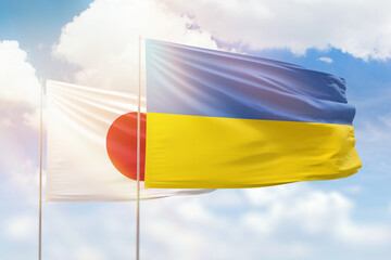 Sunny blue sky and flags of ukraine and japan