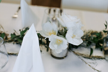 Table with green decor and flowers.  White flowers on the table.