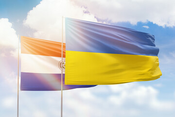 Sunny blue sky and flags of ukraine and paraguay