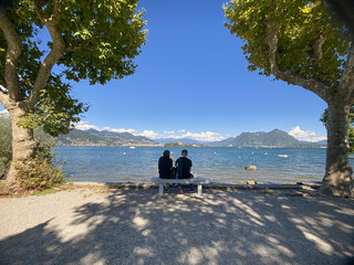 Two lovers on a bench in front of Lake Maggiore, Piedmont - Italy