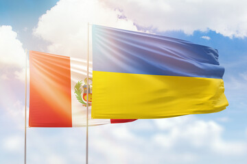 Sunny blue sky and flags of ukraine and peru